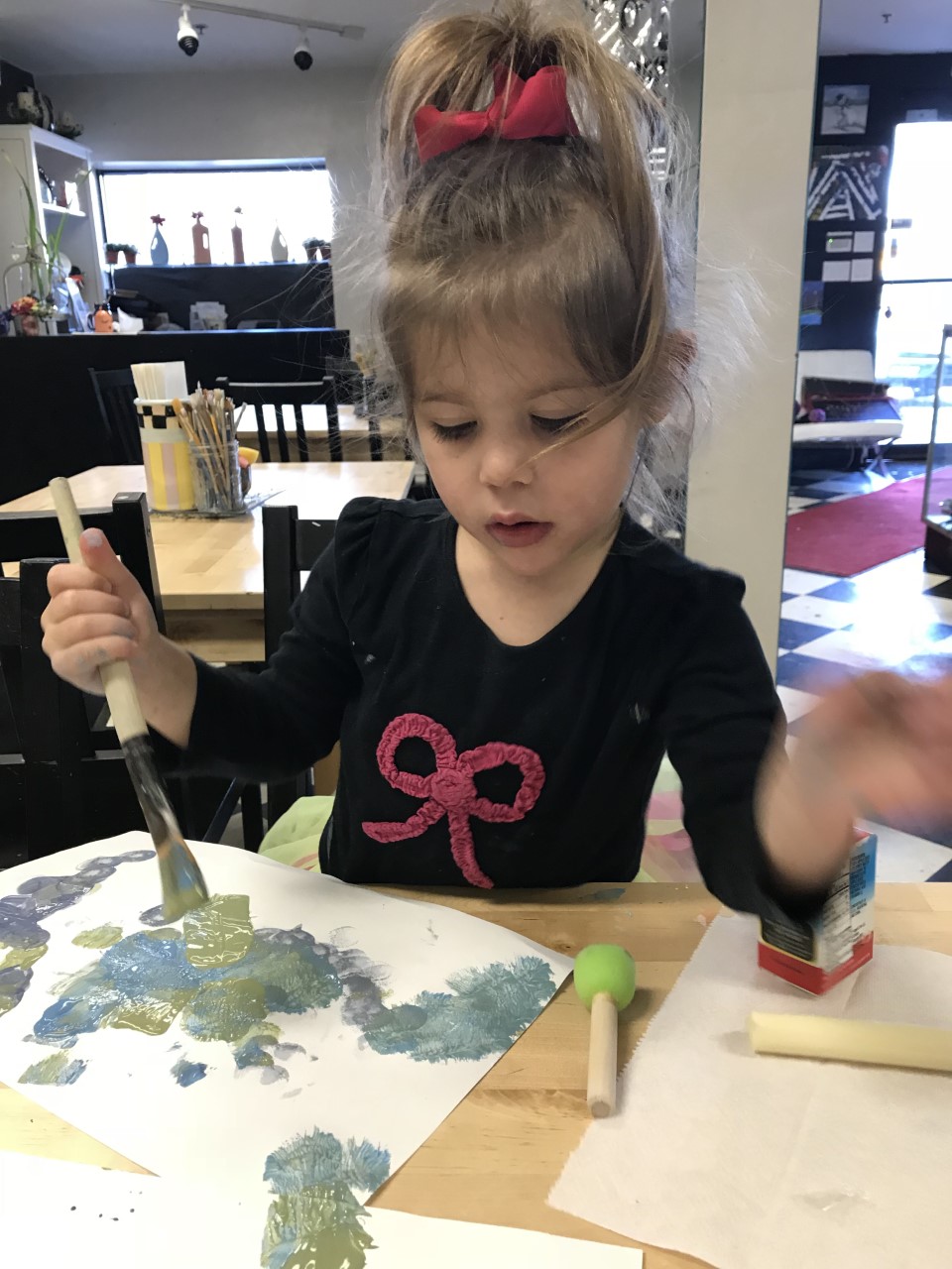 Children having a blast at a pottery party, molding and painting their unique creations